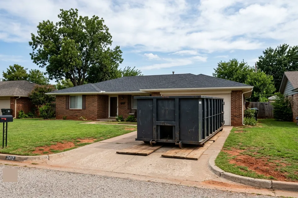 20 yard roll off dumpster rental in Lawton OK sitting on wooden boards in a brick ranch driveway